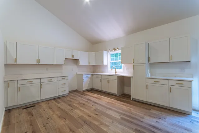 a kitchen with granite countertop white cabinets and white appliances
