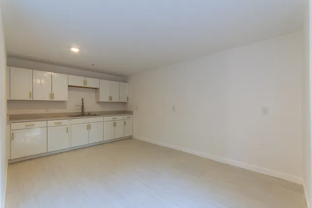 a view of a kitchen with white cabinets and a sink
