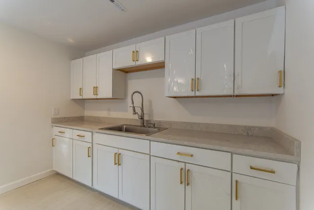 an empty room with a fan & a window