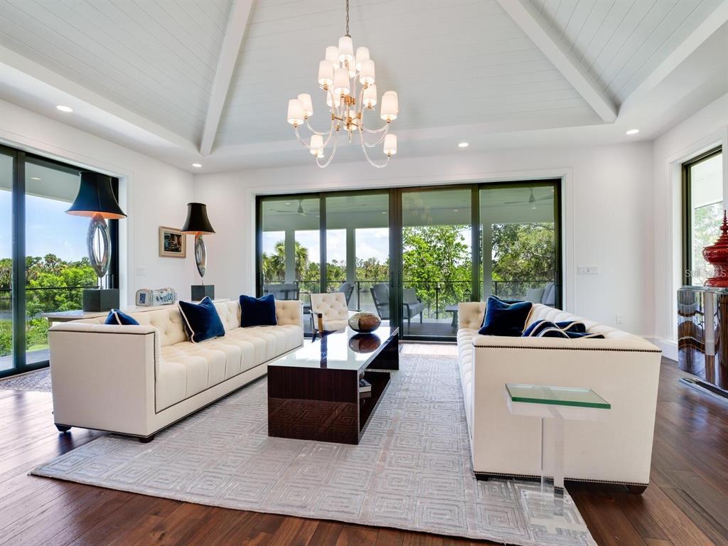 1245 Mill Creek Road Bradenton, FL 34212 - Photo 8 of 56 a living room with furniture chandelier and large windows