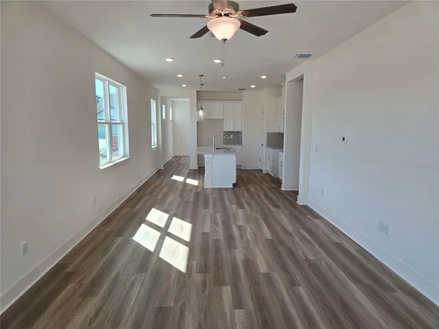 a view of a living room hardwood floor and a kitchen