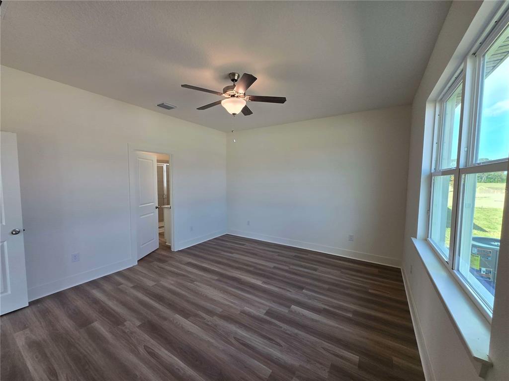 3841 Daybreak Run Loop Spring Hill, FL 34609 - Photo 5 of 11 wooden floor in an empty room with a window