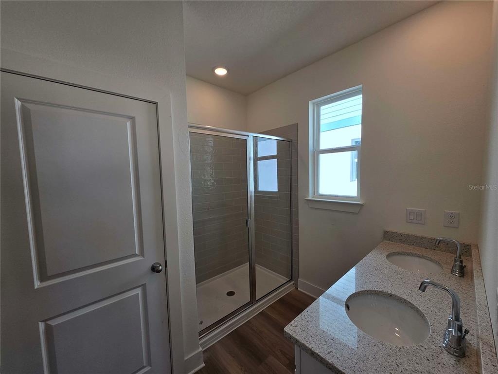 3841 Daybreak Run Loop Spring Hill, FL 34609 - Photo 6 of 11 a bathroom with a granite countertop sink a toilet and shower