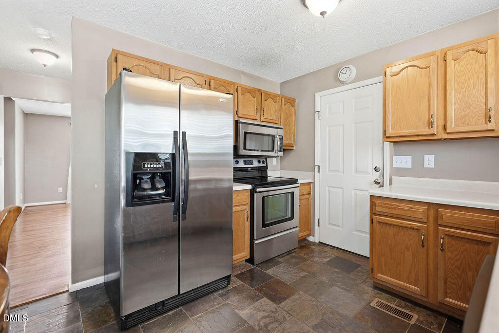 1560 Cane Mill Road Coats, NC 27521 - Photo 14 of 32 a kitchen with cabinets stainless steel appliances and a window