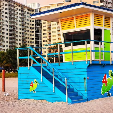 a front view of a building with river and trees
