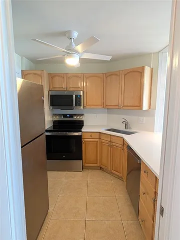 a kitchen with stainless steel appliances a refrigerator sink and microwave