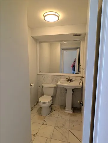 a bathroom with a toilet sink and mirror