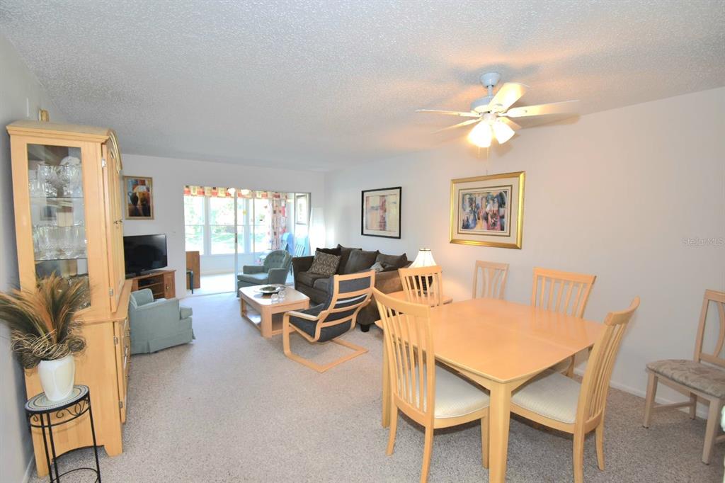 936 Virginia Street, Unit 206 Dunedin, FL 34698 - Photo 15 of 22 a living room with furniture a table and a flat screen tv