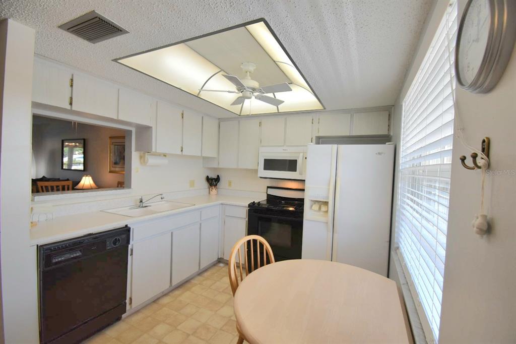 936 Virginia Street, Unit 206 Dunedin, FL 34698 - Photo 18 of 22 a kitchen with refrigerator cabinets and furniture