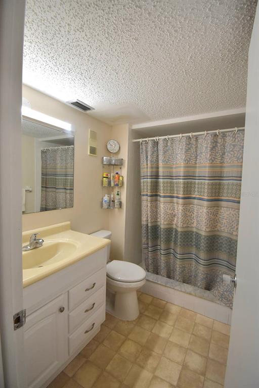 936 Virginia Street, Unit 206 Dunedin, FL 34698 - Photo 7 of 22 a bathroom with a granite countertop sink a toilet a mirror and shower