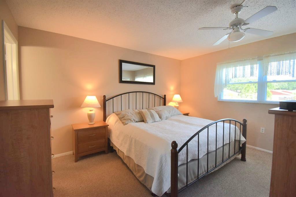 936 Virginia Street, Unit 206 Dunedin, FL 34698 - Photo 9 of 22 a bedroom with a bed and a lamp on dresser