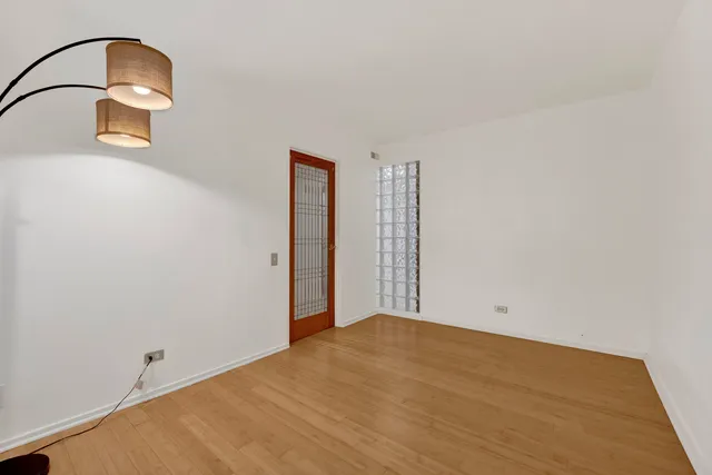 a view of a room with wooden floor and a ceiling fan