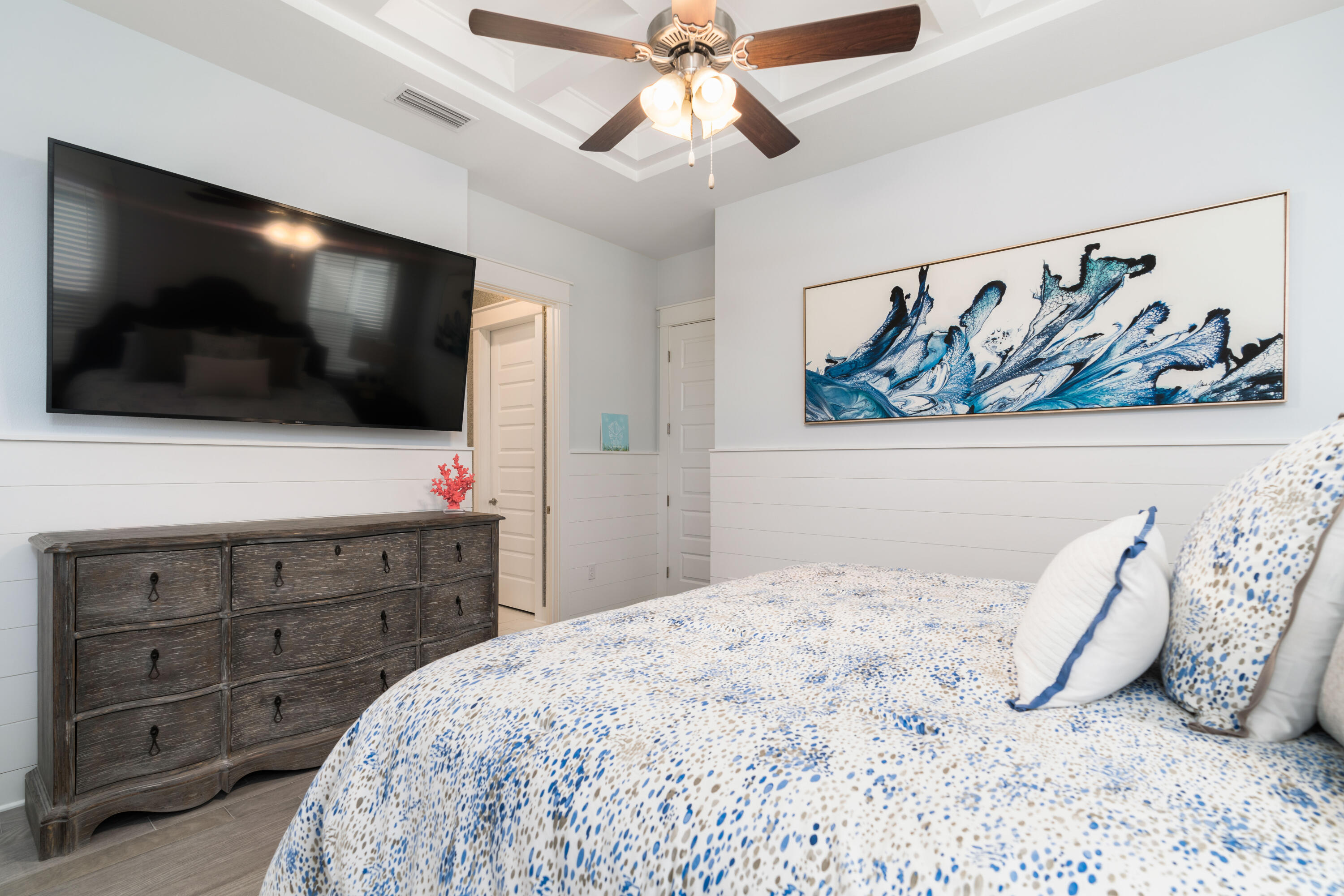 282 East Milestone Dr Inlet Beach, Unit A Inlet Beach, FL 32461 - Photo 23 of 26 a bedroom with a bed a flat screen tv and wall paintings