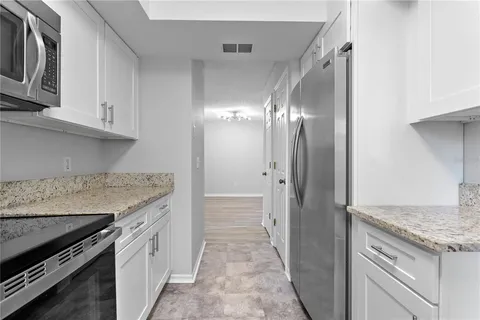 a kitchen with granite countertop a sink stove and cabinets