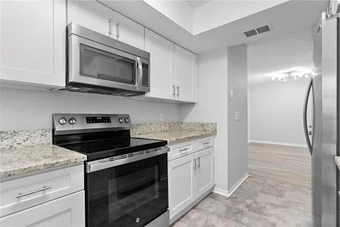 a kitchen with granite countertop cabinets and steel stainless steel appliances