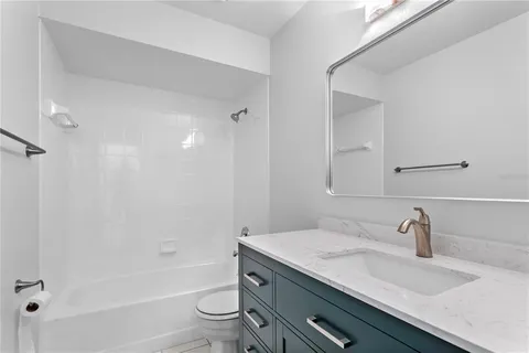 a bathroom with a granite countertop sink a toilet and shower