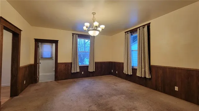 a view of a livingroom with a chandelier fan and a large window