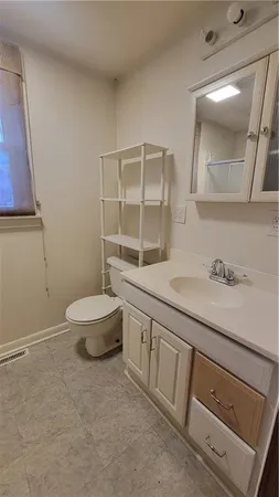 a bathroom with a granite countertop sink a toilet and a mirror