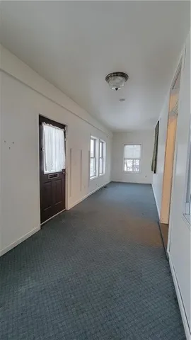 a view of an empty room and window and fire place