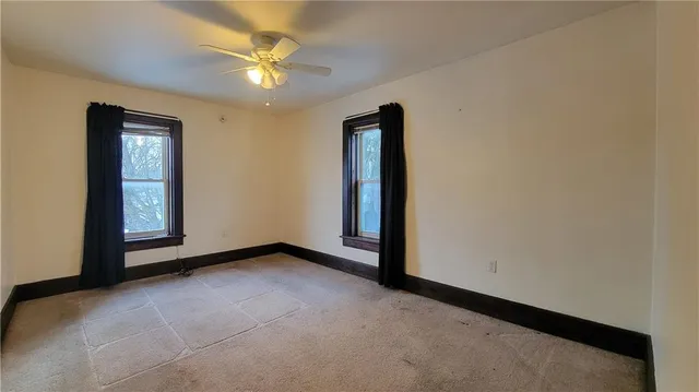 an empty room with closet and a ceiling fan