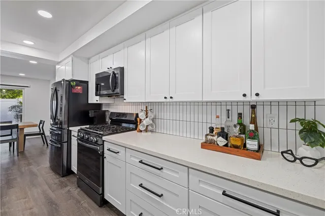 a kitchen with stainless steel appliances white cabinets and a stove top oven