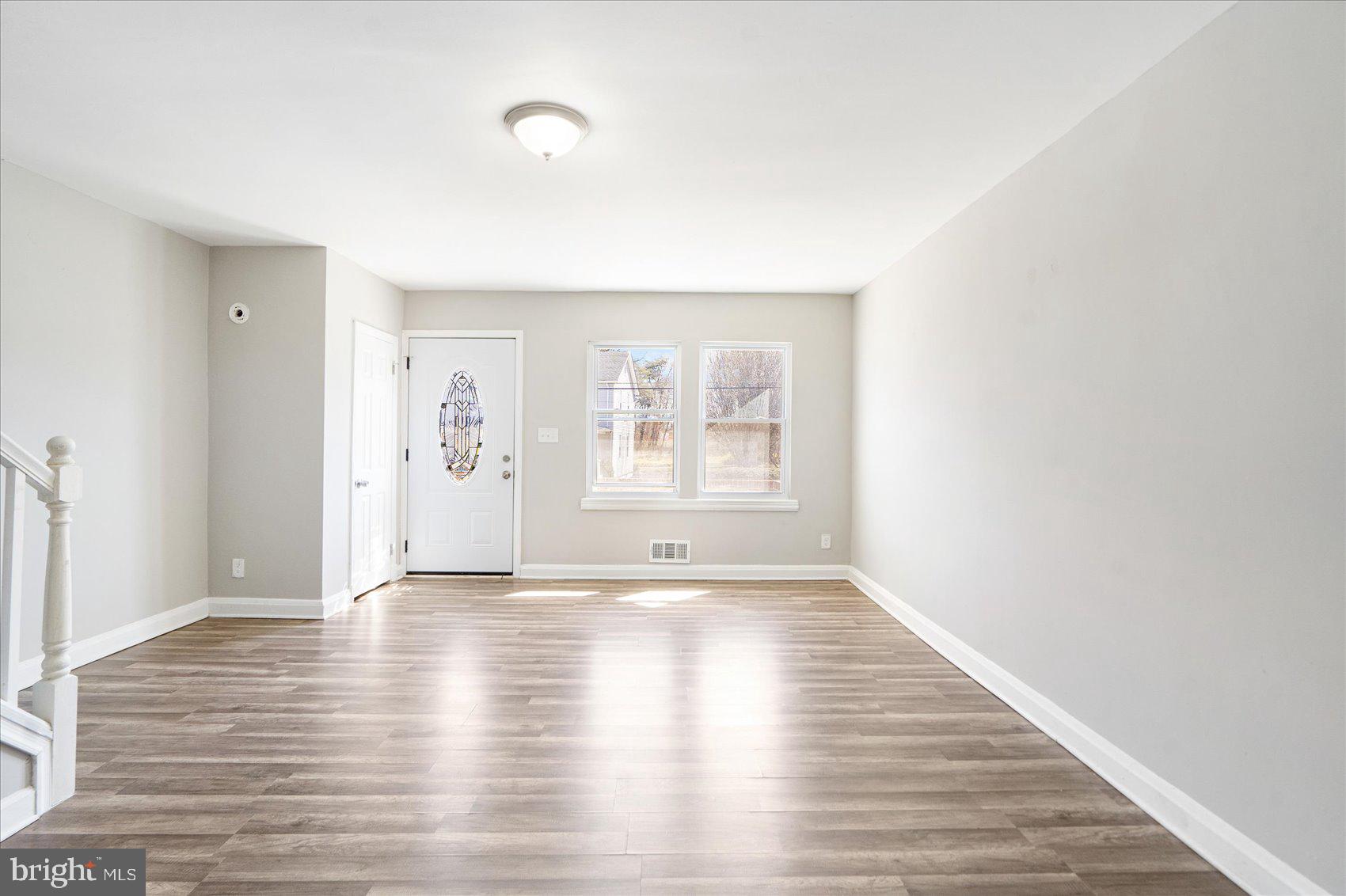 706 Norris Lane Baltimore, MD 21221 - Photo 13 of 36 a view of an empty room with window and wooden floor