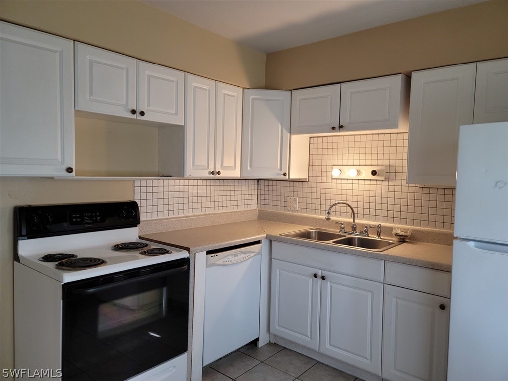 114 Florida Road Lehigh Acres, FL 33936 - Photo 3 of 12 a kitchen with cabinets stainless steel appliances a sink and a stove