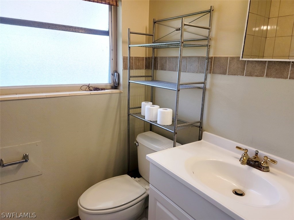114 Florida Road Lehigh Acres, FL 33936 - Photo 8 of 12 a bathroom with a sink a toilet and a mirror