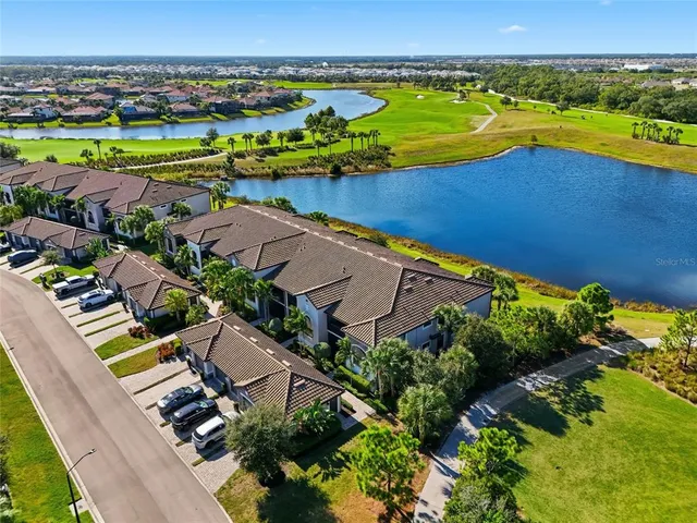 an aerial view of ocean and residential houses with outdoor space