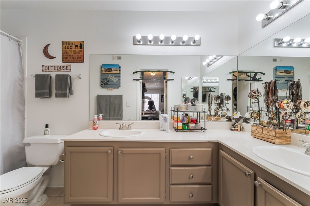 1575 West Warm Springs Road, Unit 2822 Henderson, NV 89014 - Photo 25 of 37 Full bathroom featuring double vanity, toilet, and tile patterned flooring
