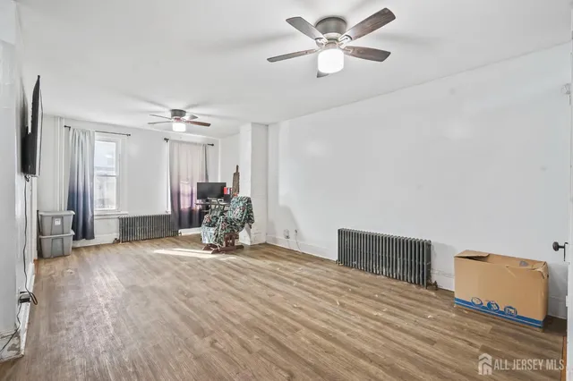 a view of a livingroom with a ceiling fan and hardwood floor