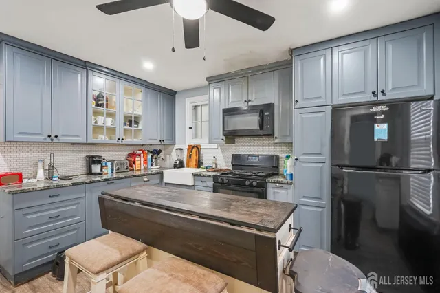 a kitchen with a refrigerator a stove a sink cabinets and wooden floor