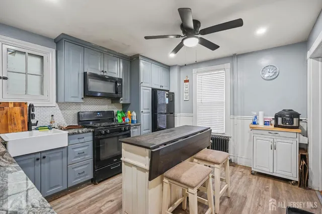 a kitchen with stainless steel appliances granite countertop a stove refrigerator sink and microwave