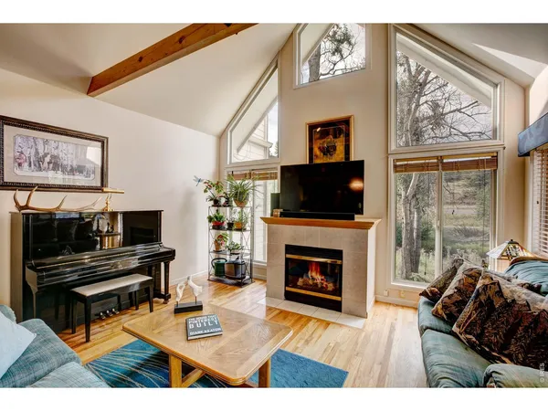a living room with furniture a rug and a piano
