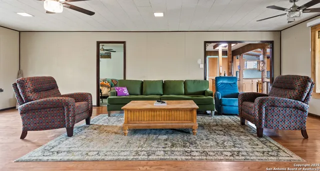 a view of a dining room with furniture a chandelier and wooden floor