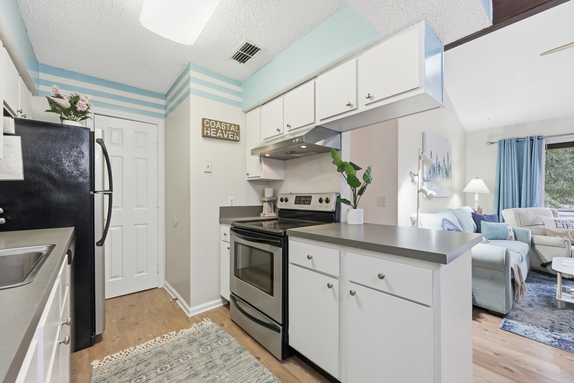 2886 Forest Ridge Drive, Unit U6 Fernandina Beach, FL 32034 - Photo 15 of 43 a kitchen with stainless steel appliances granite countertop a sink a refrigerator a stove and white cabinets with wooden floor