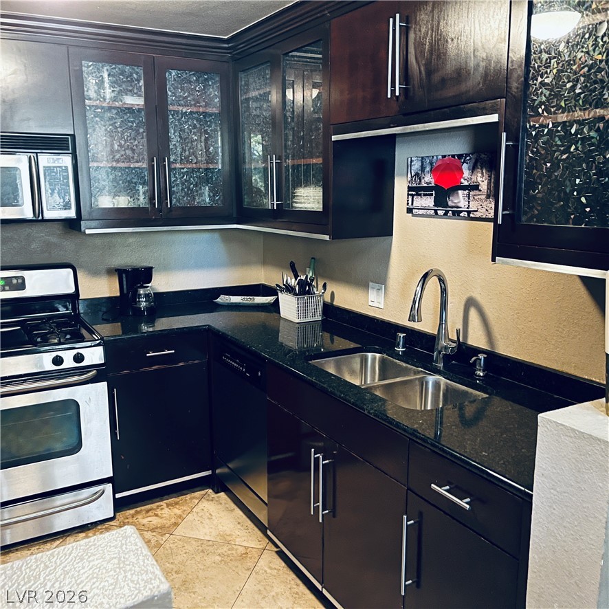 260 East Flamingo Road, Unit 118 Las Vegas, NV 89169 - Photo 7 of 9 A well-appointed kitchen features dark wood cabinetry with sleek hardware and rich countertops.
