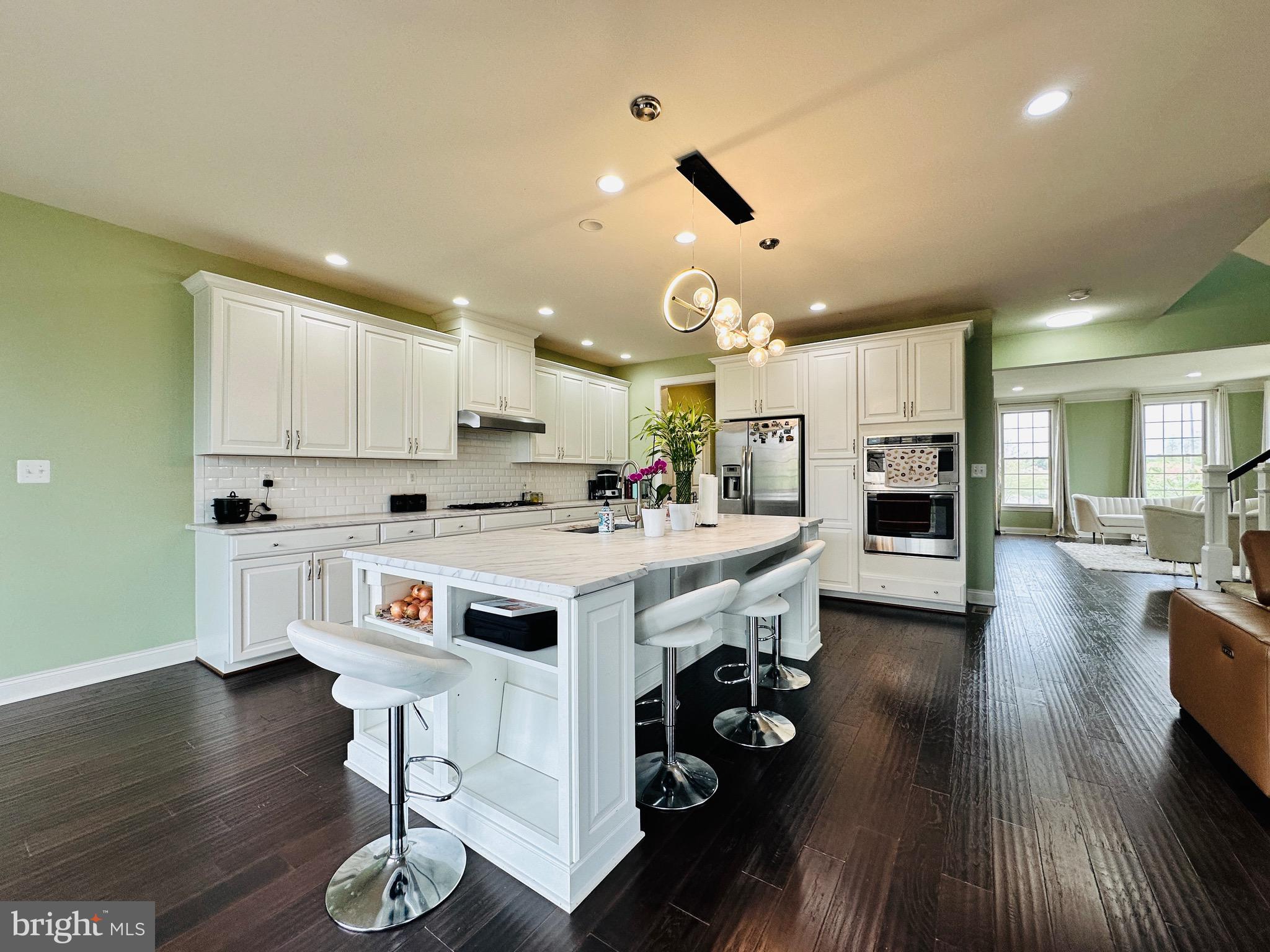22611 Windsor Locks Square Ashburn, VA 20148 - Photo 11 of 53 a kitchen with stainless steel appliances a stove a sink dishwasher and a refrigerator with wooden floor