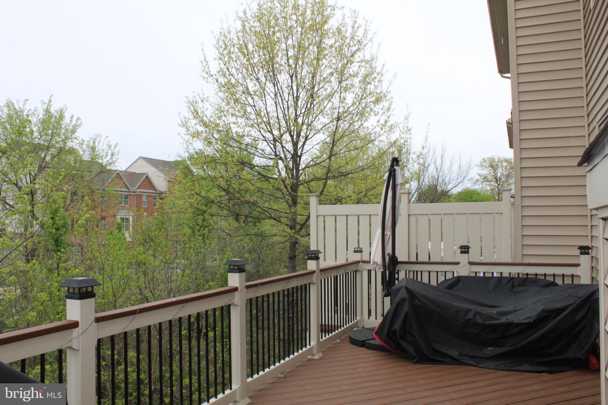 22611 Windsor Locks Square Ashburn, VA 20148 - Photo 50 of 53 a view of a roof deck with wooden fence and trees