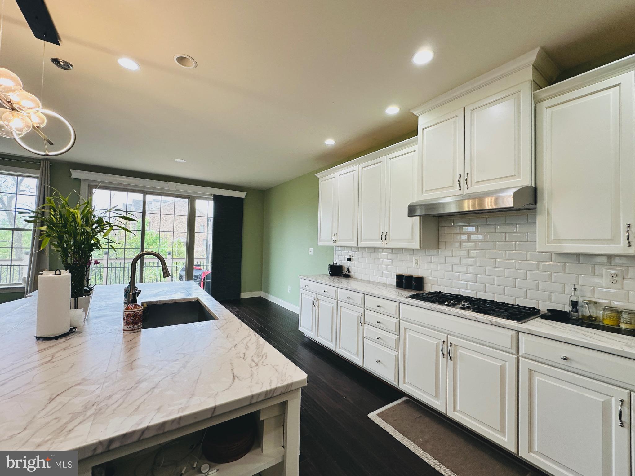 22611 Windsor Locks Square Ashburn, VA 20148 - Photo 8 of 53 a kitchen with granite countertop a sink a stove cabinets and living room view