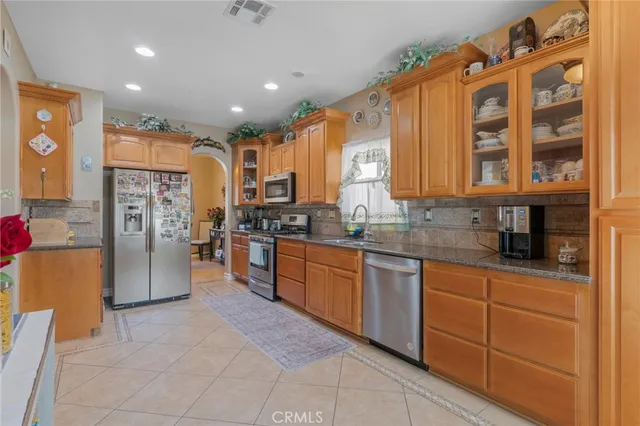 a kitchen with stainless steel appliances granite countertop a refrigerator and a stove top oven