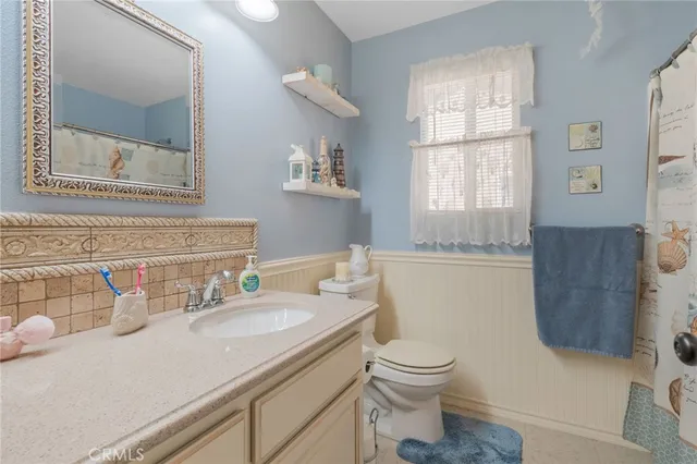 a bathroom with a granite countertop toilet sink and mirror