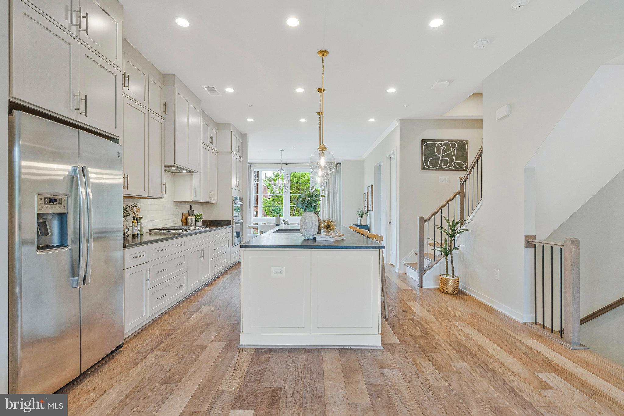 11724 Paysons Way Reston, VA 20191 - Photo 11 of 41 a kitchen with stainless steel appliances granite countertop a refrigerator a sink dishwasher a stove and white countertops with wooden floor