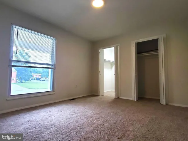 an empty room with windows and closet