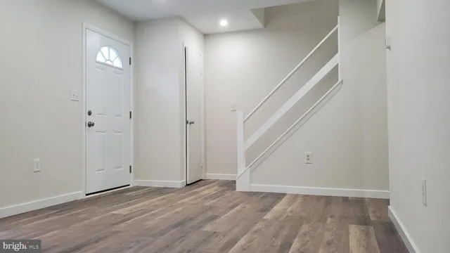 an empty room with wooden floor and entryway