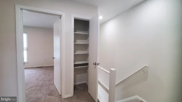 a view of walk in closet with empty racks