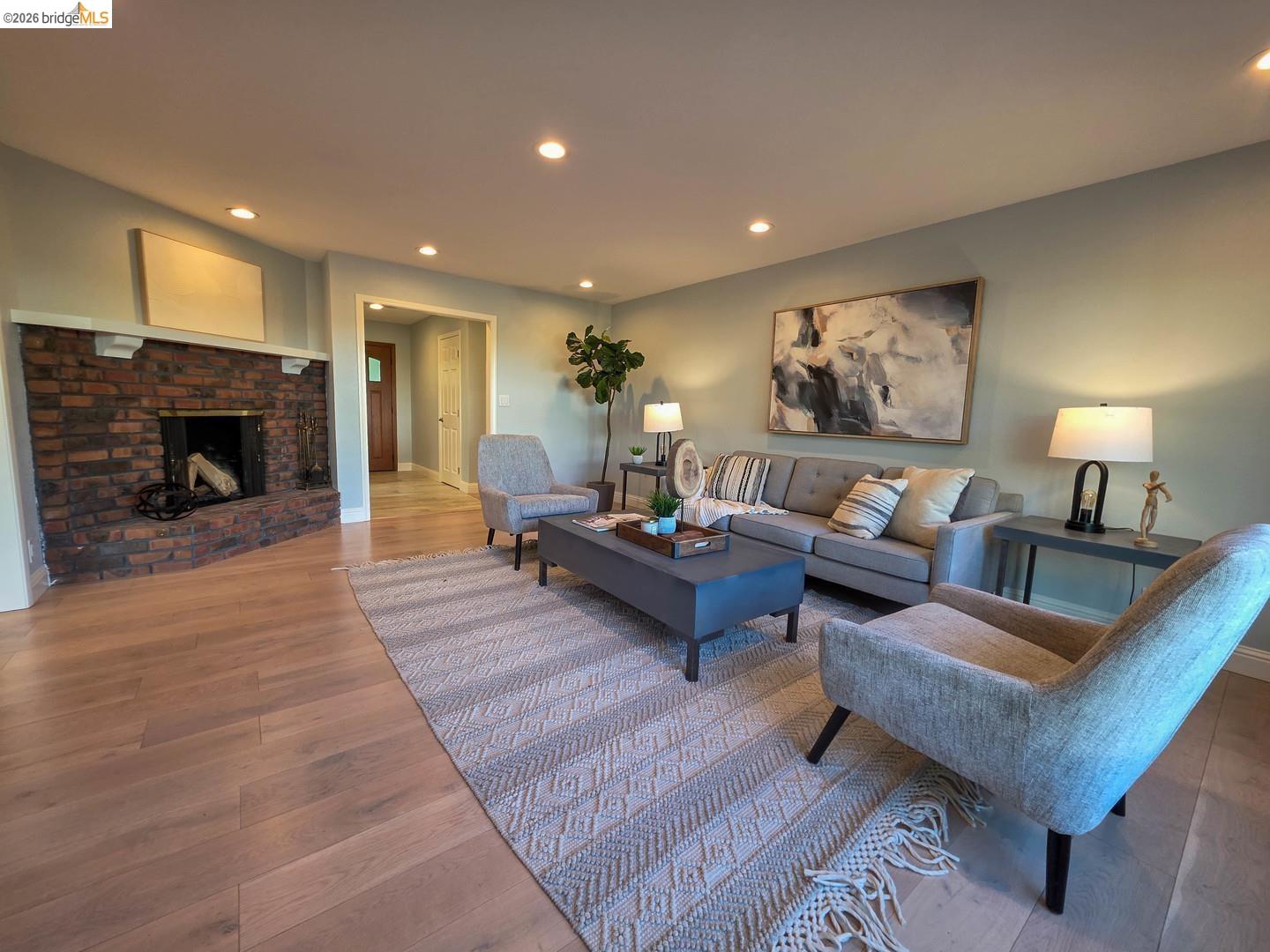 965 Springer Road Los Altos, CA 94024 - Photo 4 of 31 Spacious living area featuring a brick fireplace with a white mantel, recessed lighting, wood-finish flooring, and a wide entryway