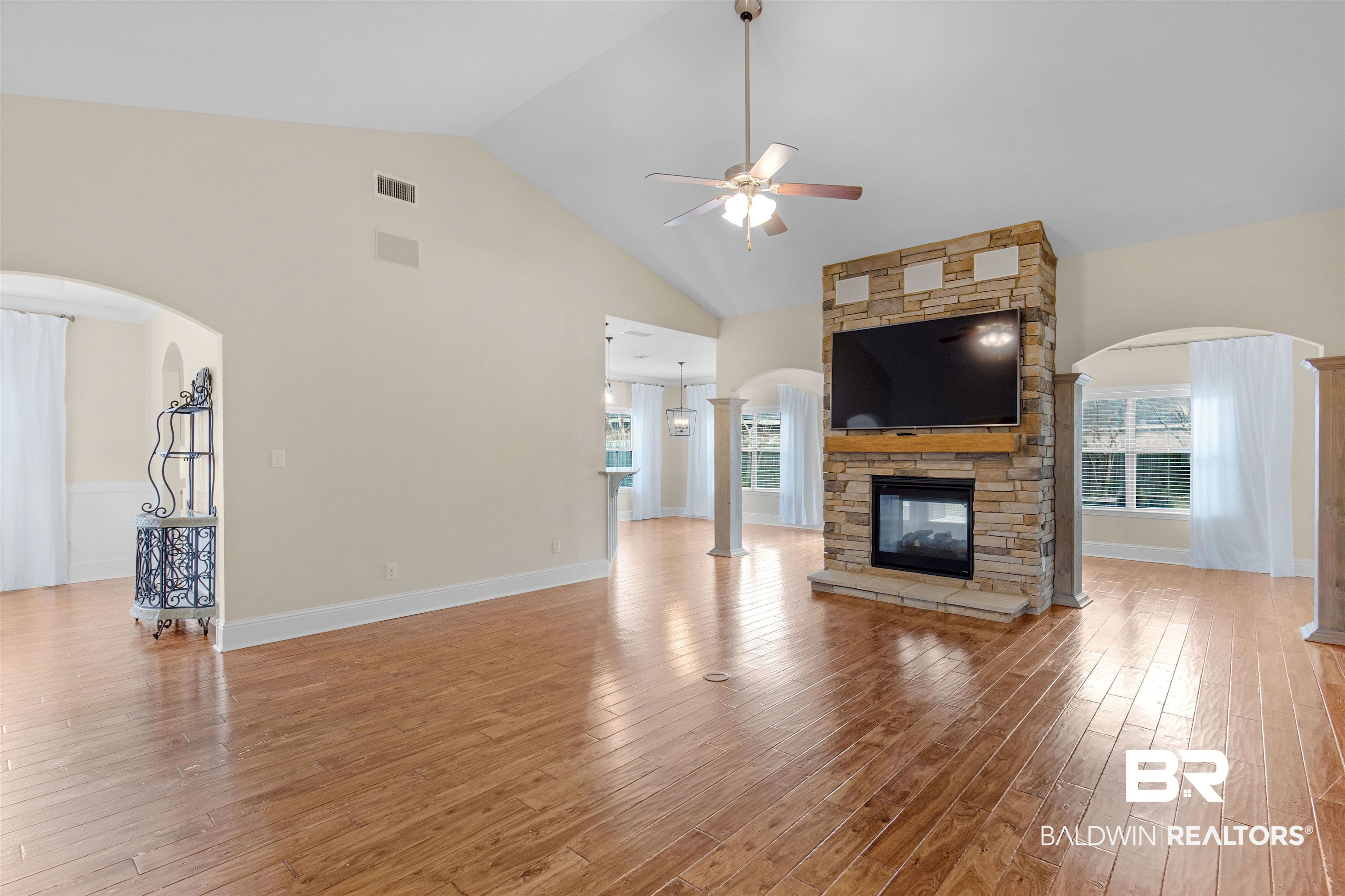25092 Fairfax Road Daphne, AL 36526 - Photo 6 of 29 Unfurnished living room featuring ceiling fan, a fireplace, high vaulted ceiling, and wood-type flooring
