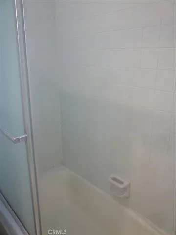 a white toilet sitting next to a shower