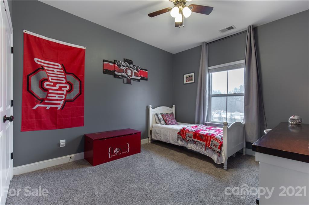 86512 Arrington Road Lancaster, SC 29720 - Photo 21 of 31 a bedroom with bed and a chandelier